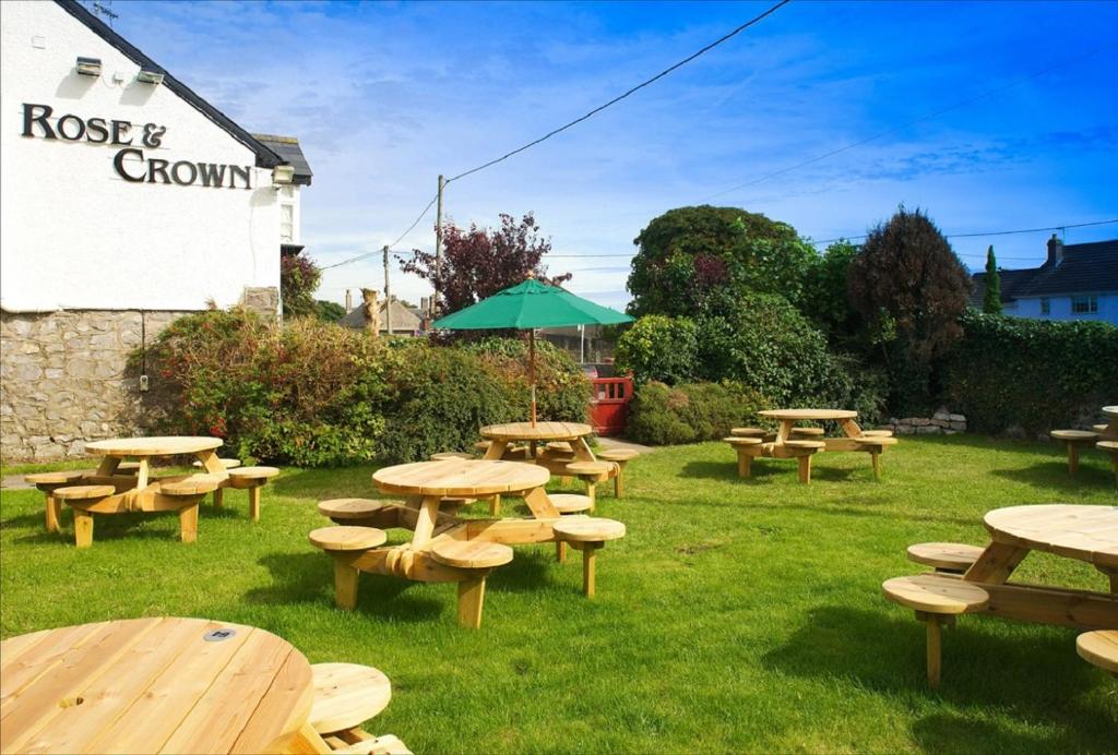a group of picnic tables and benches in the grass at Rose And Crown in Porthcawl