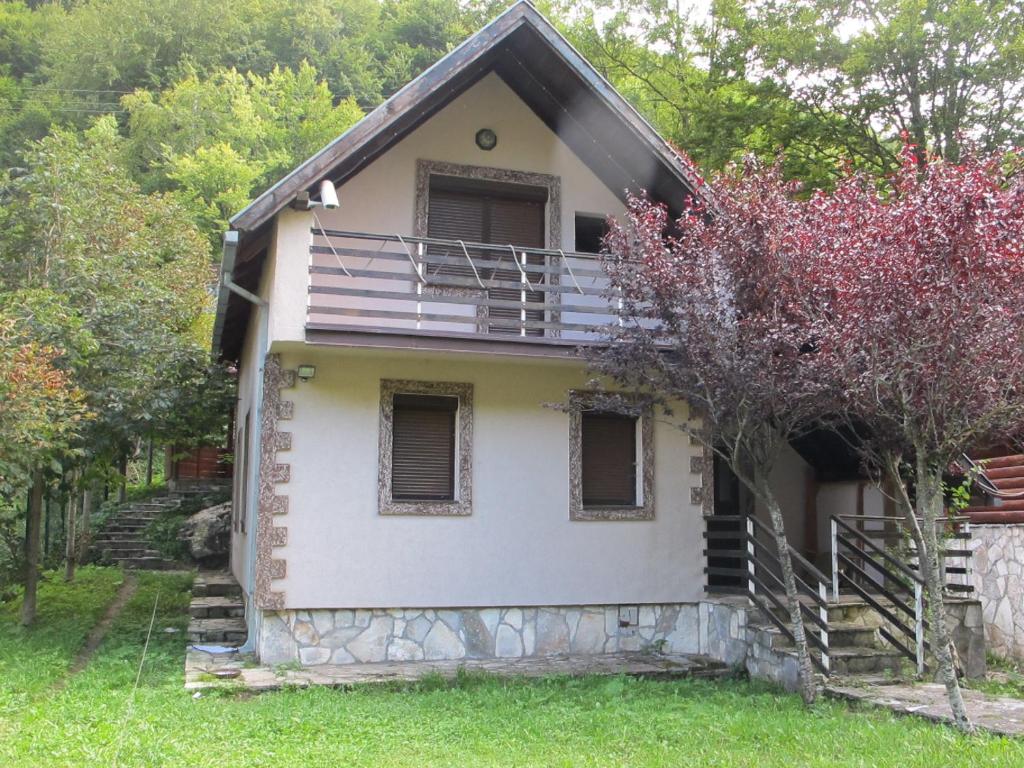 una piccola casa bianca con un albero di Biocinovici vikendica a Kolašin
