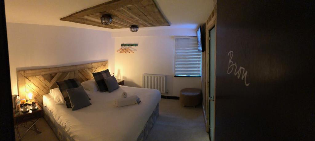 a hotel room with a bed, table and a window at The Wiremill Sleep Boutique in Felbridge