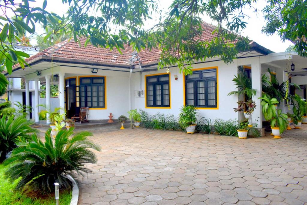 a white house with a courtyard in front of it at Old Park Villa in Jaffna