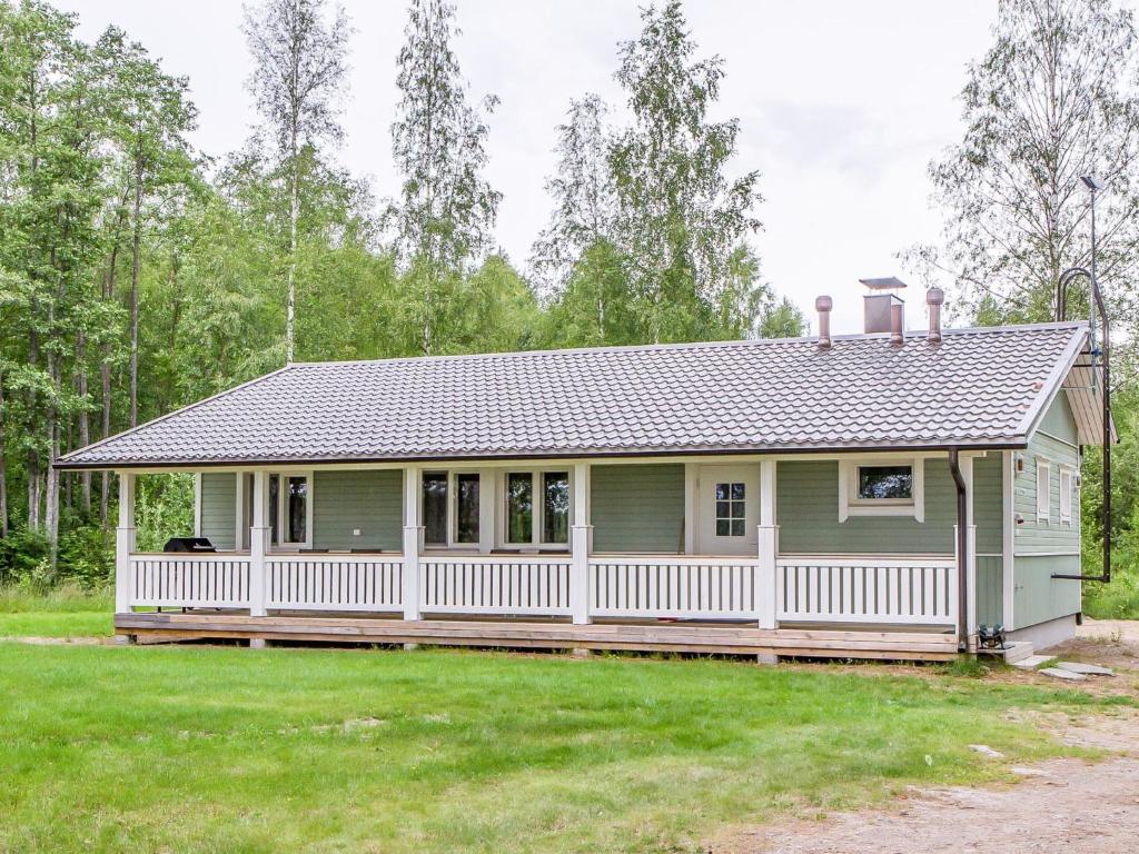 una pequeña casa verde con una valla blanca en Holiday Home Petäjäniemi by Interhome, en Leskelä