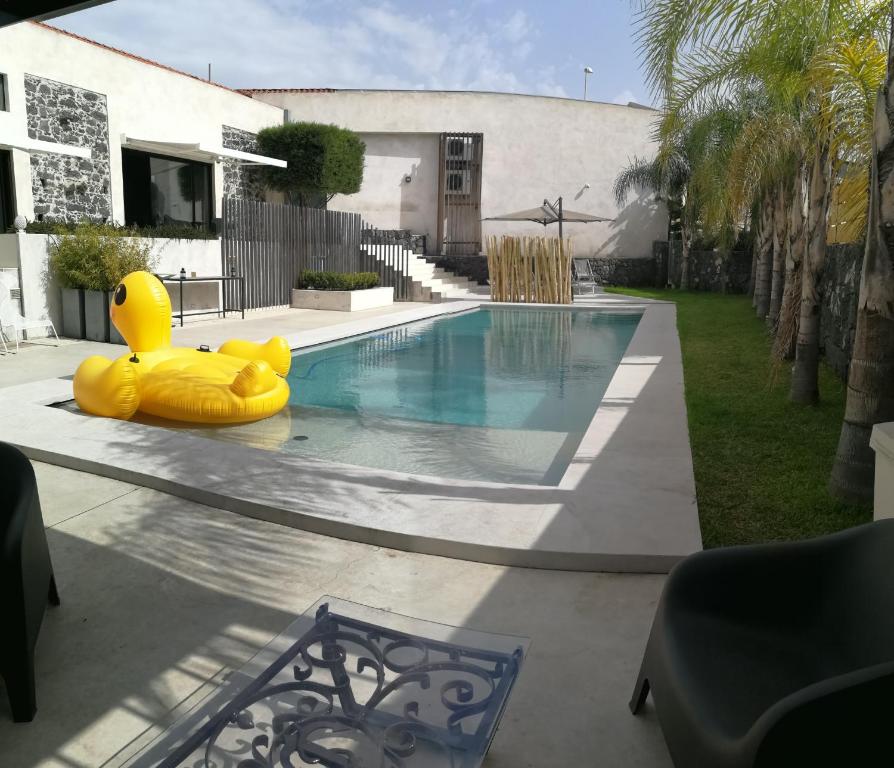 Un canard gonflable en caoutchouc se trouve à côté d'une piscine. dans l'établissement Sciara Biscari B&B, à Catane