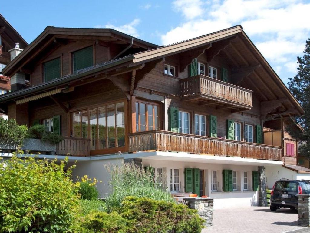 a large wooden house with a balcony at Apartment Krebs by Interhome in Adelboden