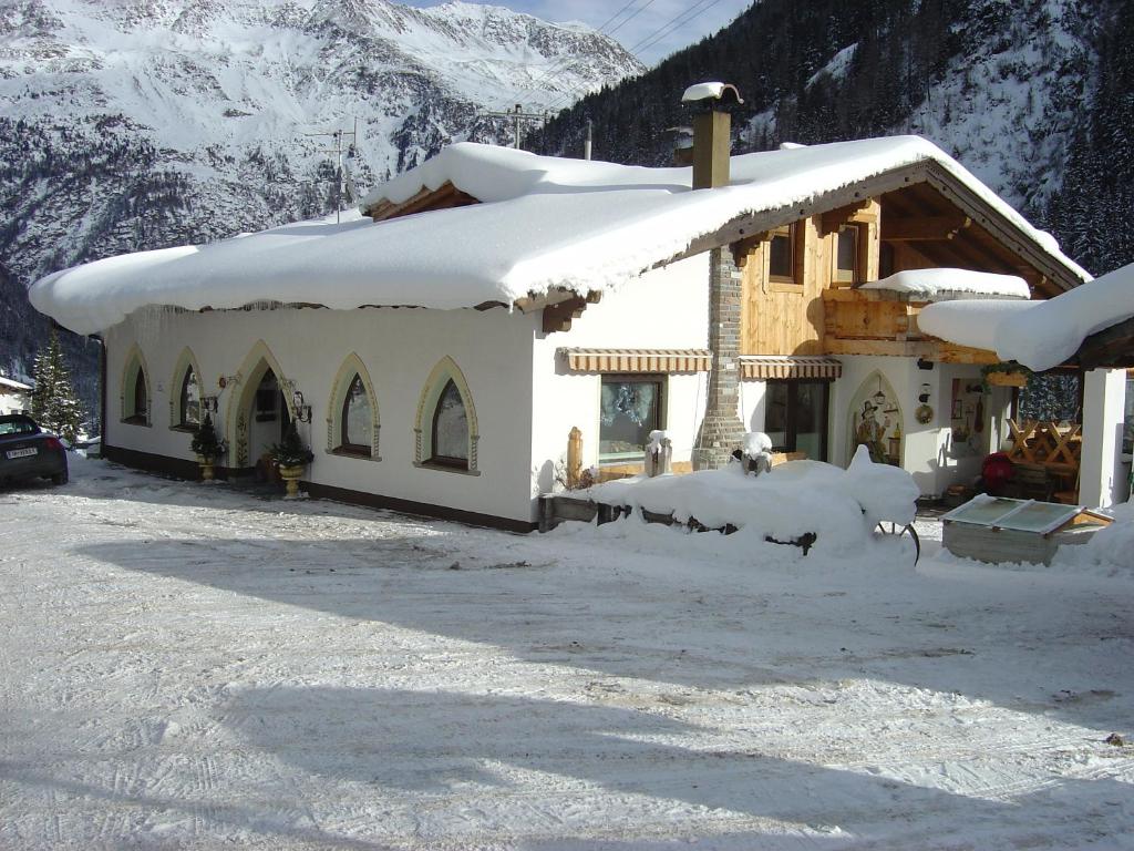 a house covered in snow in front of a mountain at Apart Gentiana in Sölden