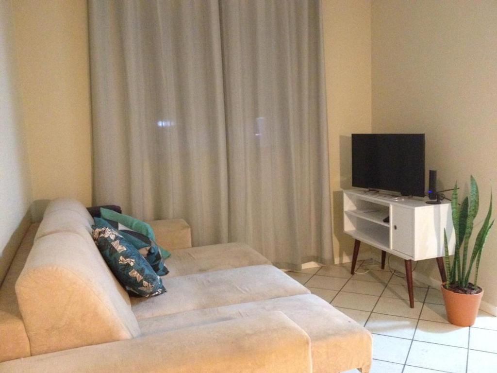 a living room with a couch and a flat screen tv at Apartamento Vila do Sol in Blumenau