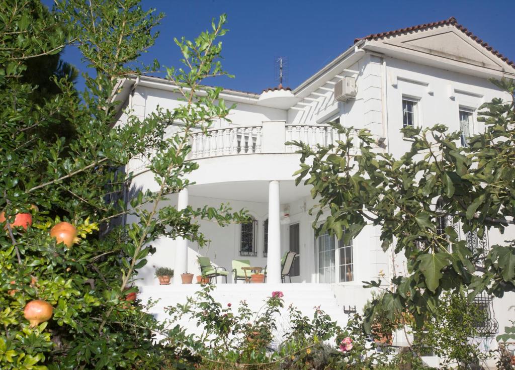 una casa bianca con degli alberi di fronte di Home Katerina a Kýmina