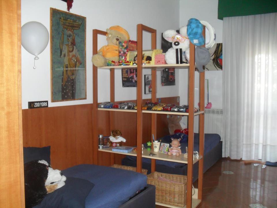 una stanza con mensola, giocattoli e letto di Casa di Paola a Napoli