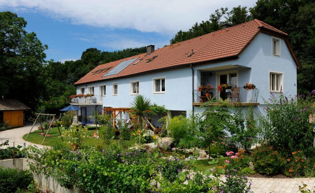 a white house with a garden in front of it at Privatzimmer Langthaler in Melk