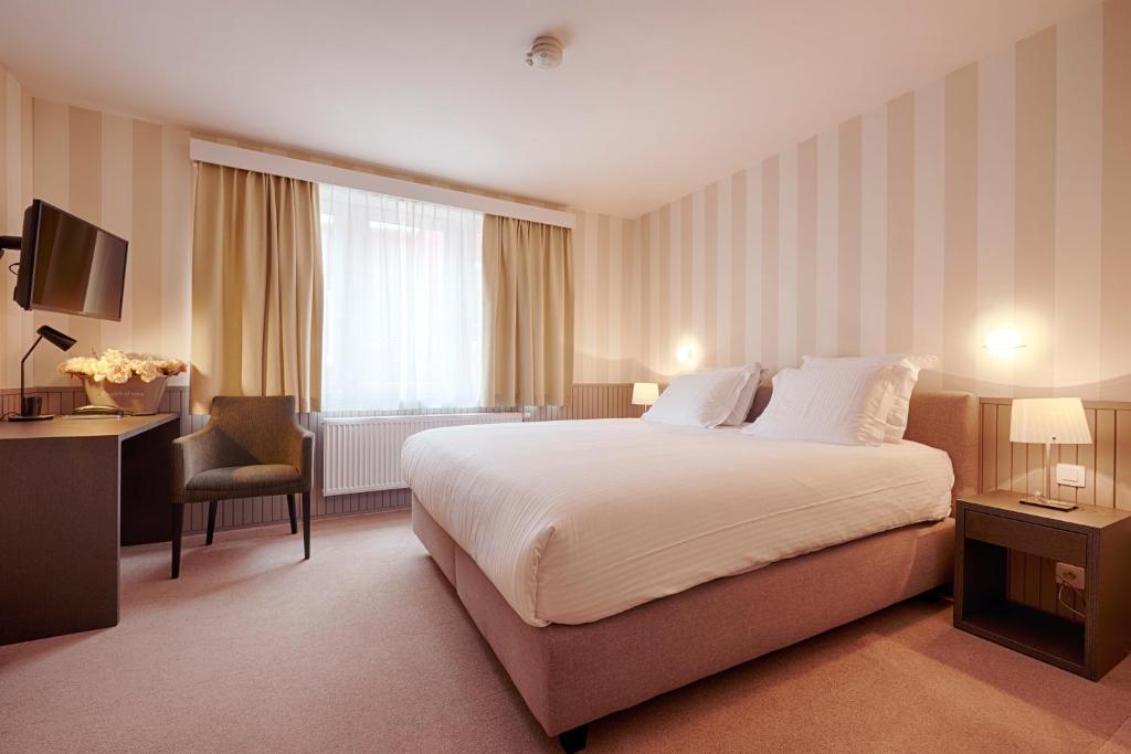 a hotel room with a large bed and a desk at Hotel 't Putje in Bruges