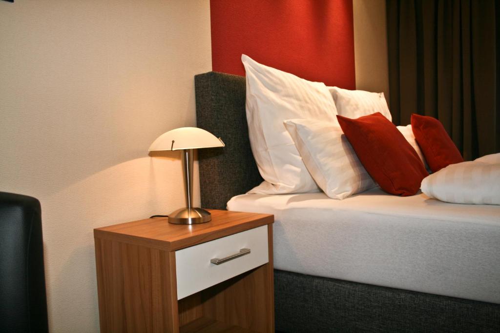 a hotel room with a bed with red and white pillows at Haus Elisabeth in Bad Salzungen