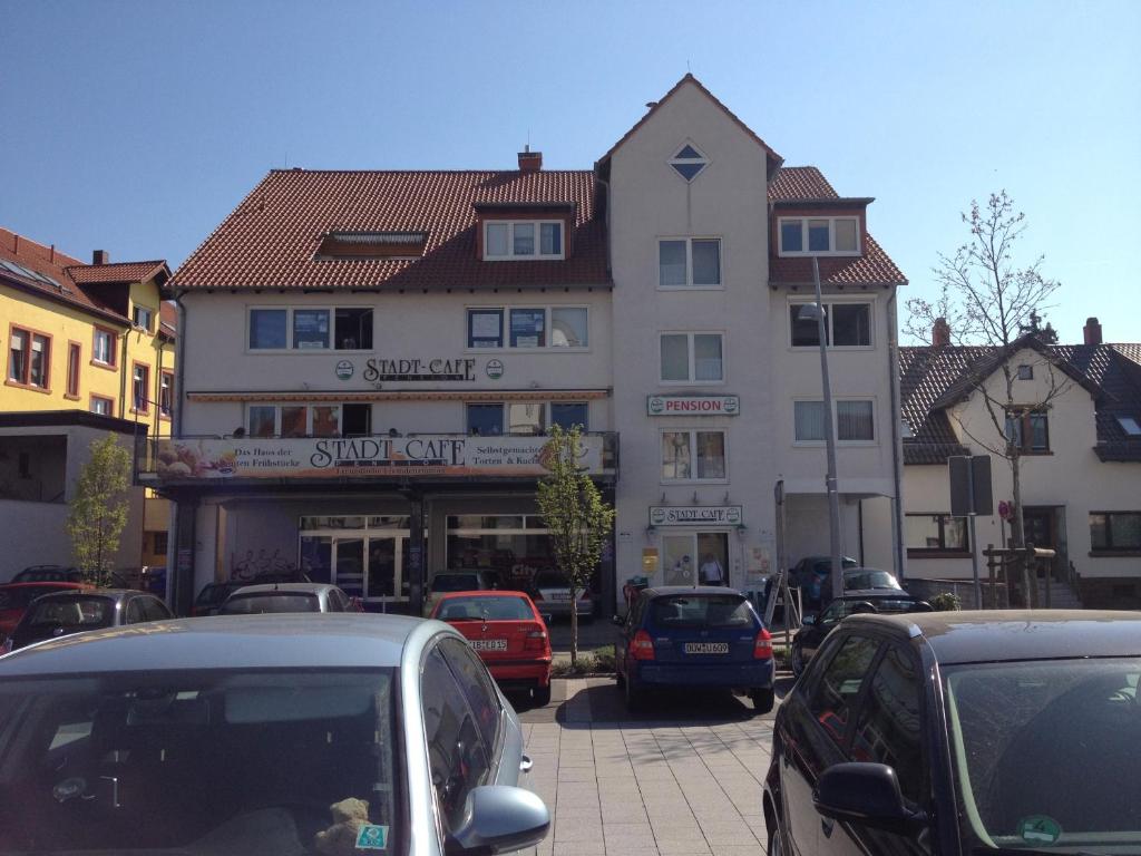 a street with cars parked in front of a building at StadtCafé Pension in Grünstadt