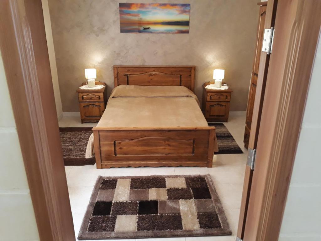 a bedroom with a bed and two night stands at Grazzja Traditional Apartment in Żabbar