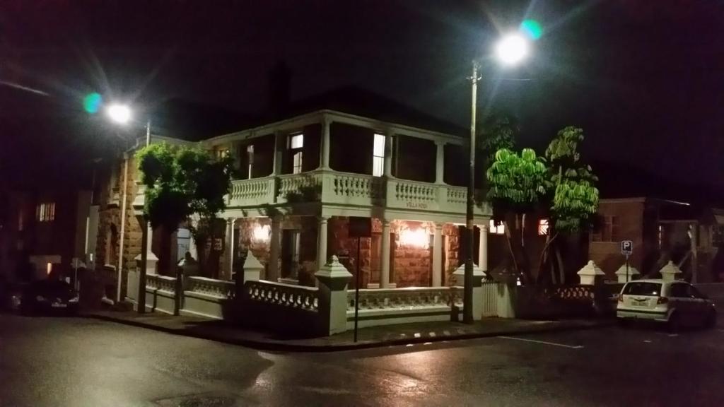 una casa con dos luces verdes en una calle en Hostel Villa Nova, en Mossel Bay