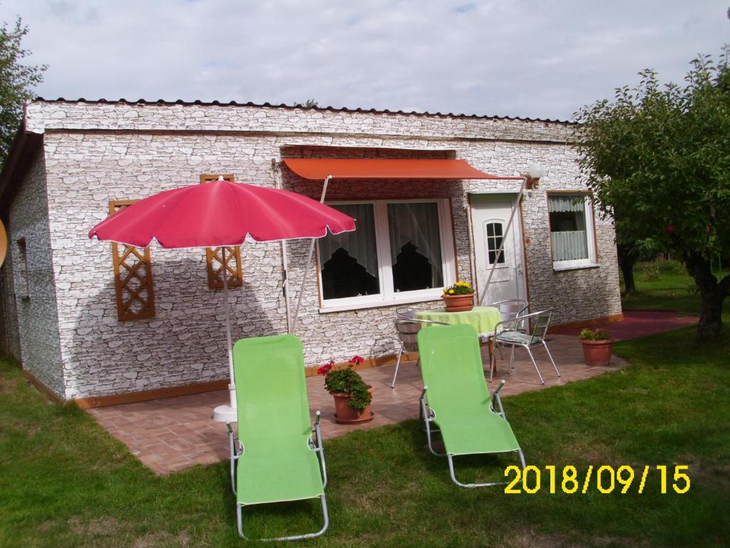 eine Terrasse mit einem Tisch, Stühlen und einem Sonnenschirm in der Unterkunft Unterkünfte in Zarrendorf in Zarrendorf