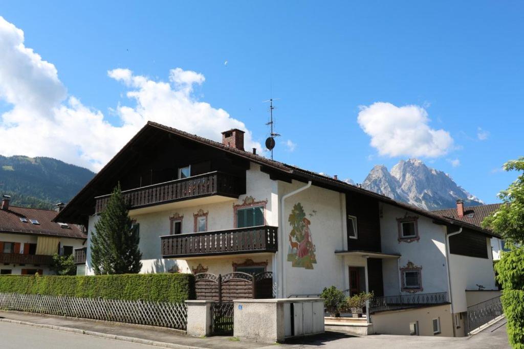 duży dom z górami w tle w obiekcie Mountain View Apartment w Garmisch Partenkirchen