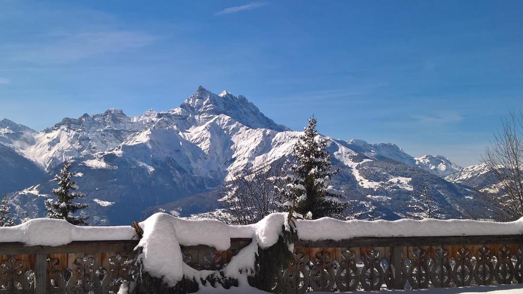 a snow covered mountain in front of a fence at Domaine de La Croix de Javernaz in Villars-sur-Ollon