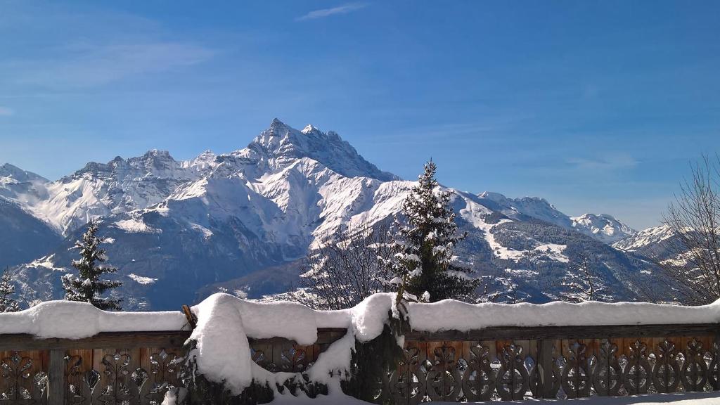 einen schneebedeckten Berg vor einem Zaun in der Unterkunft Domaine de La Croix de Javernaz in Villars-sur-Ollon