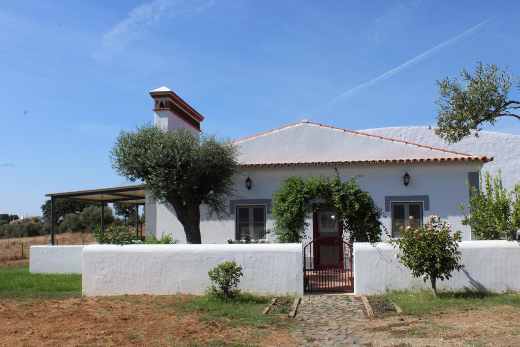 una casa blanca con una puerta delante de ella en Herdade dos Alfanges "THE FARMHOUSE", en Vila Nova da Baronia