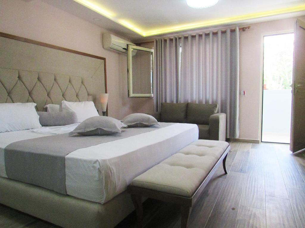 a bedroom with a large bed and a couch at Hotel ANTAG in Shëngjin