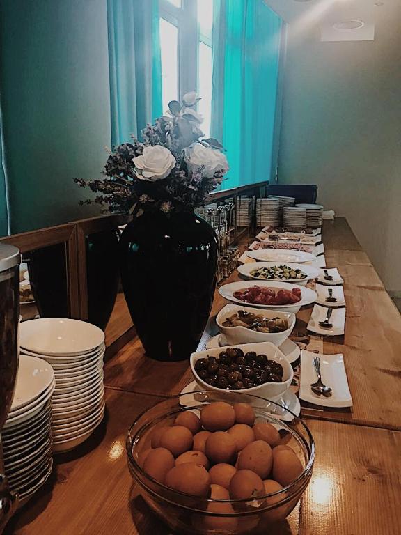 a long table with plates and bowls of food at Hotel ANTAG in Shëngjin