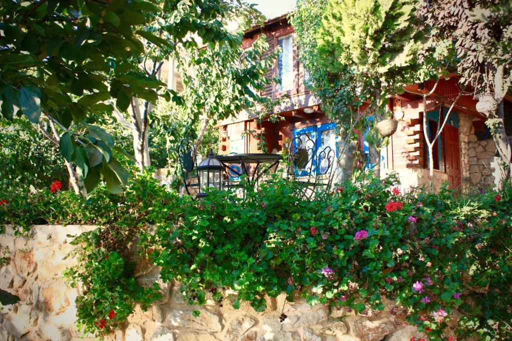 a stone wall with flowers in front of a house at Zimer Al-Bayt in Mas'ade