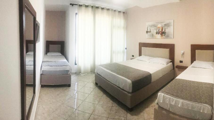 a hotel room with two beds and a window at Hotel ANTAG in Shëngjin