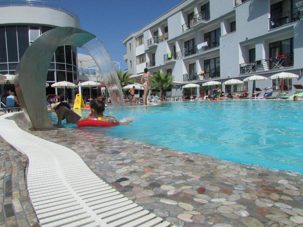 2 bambini che giocano in una piscina di un hotel di Hotel ANTAG a Shëngjin