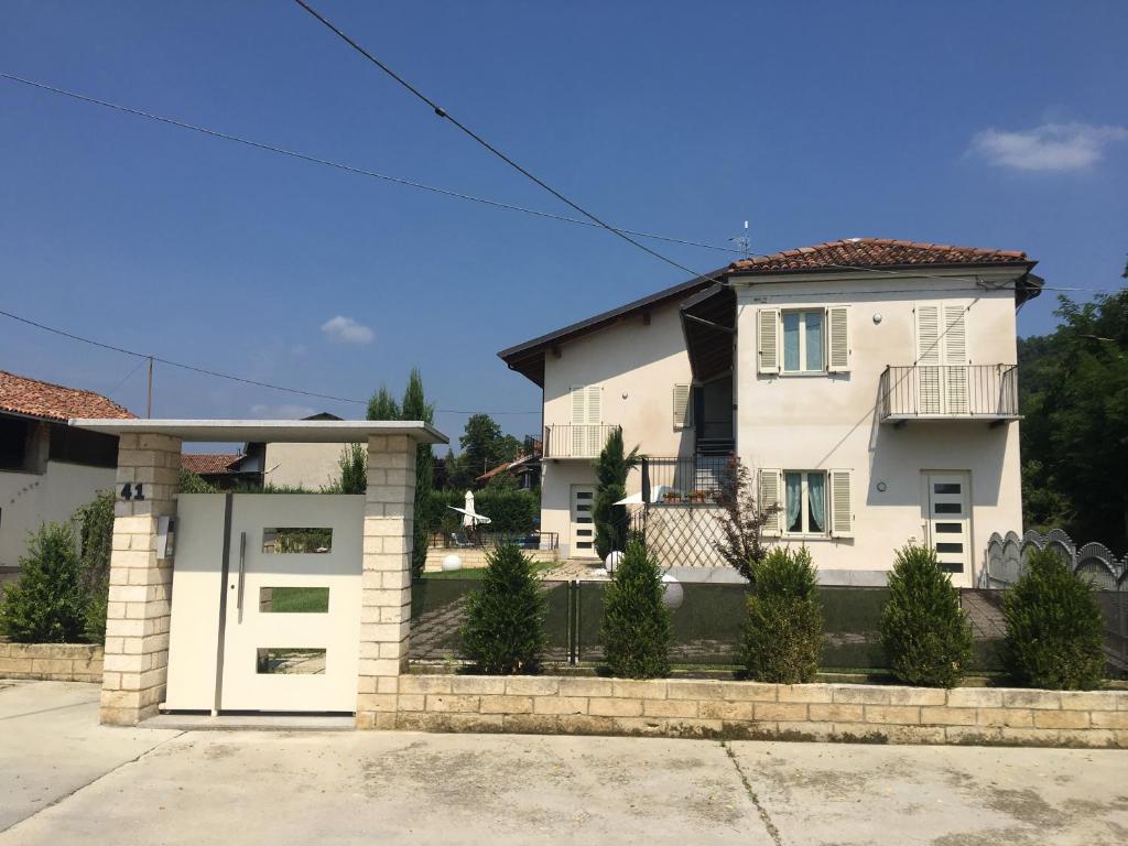 a white house with a gate and a garage at Home Holiday "Da Mamma" in Alba