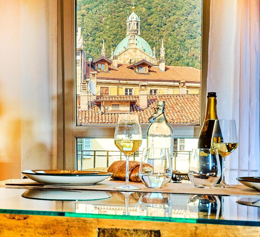 una mesa con copas de vino y vistas a la ciudad en 21 Lake Sweet Home, en Como