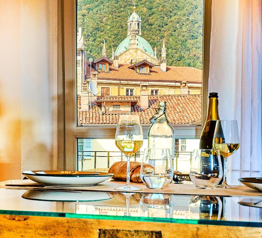 a table with wine glasses and a view of a city at 21 Lake Sweet Home in Como