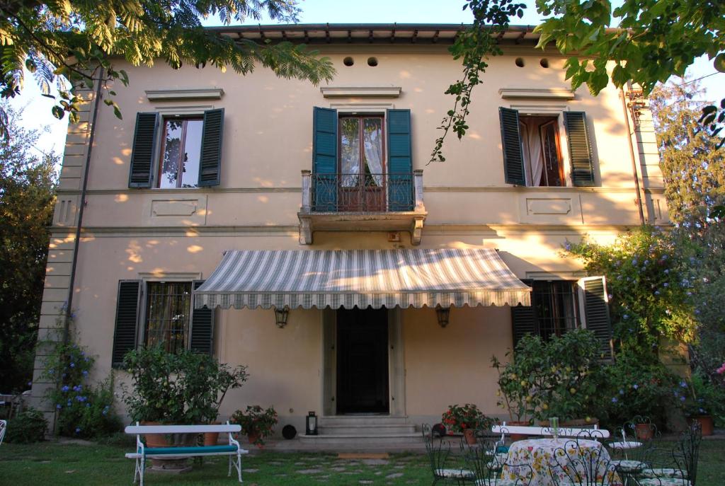 a building with a balcony and a table in front of it at Villa Carola in San Giuliano Terme