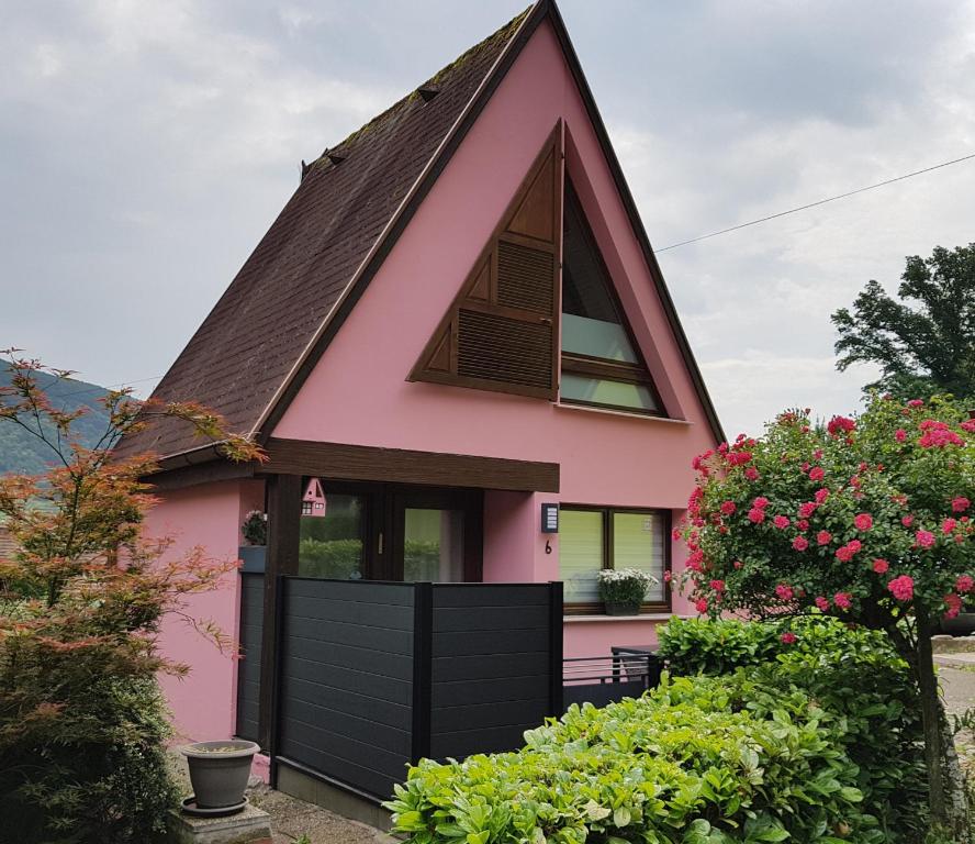 uma casa cor-de-rosa com um telhado de gambrel em Gite Delphine em Kaysersberg