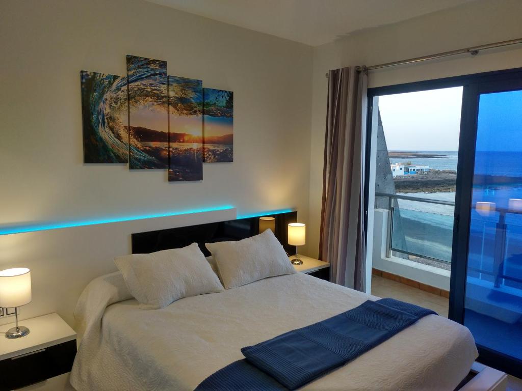 una camera con un letto e una grande finestra di Ocean Front Apartment (WiFi) a Tetir