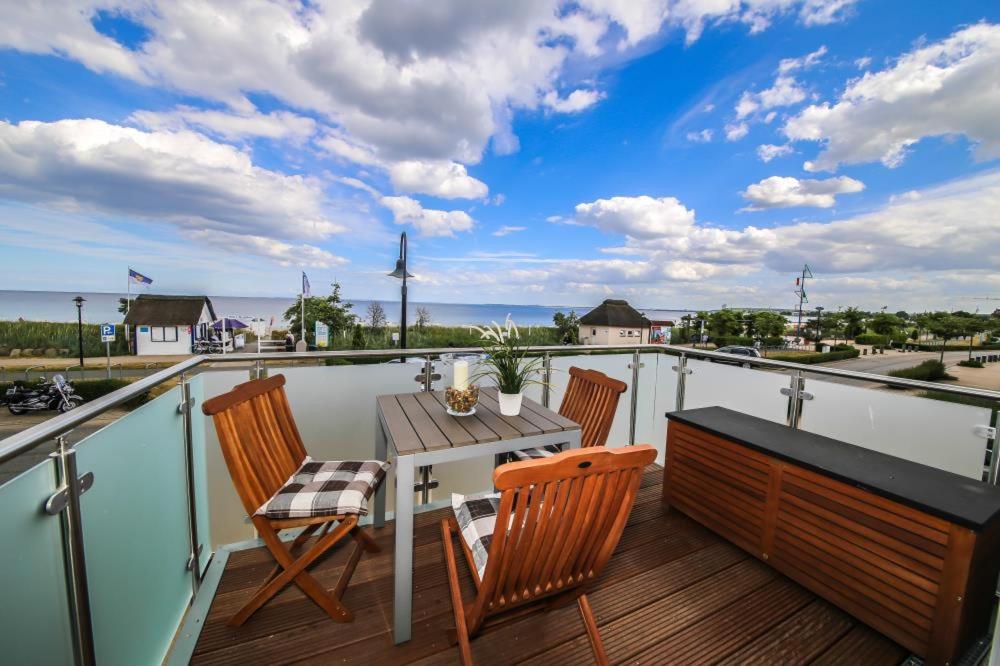 a balcony with a table and two chairs and the ocean at Ferienwohnung 2 Haus Meeresrauschen in Haffkrug