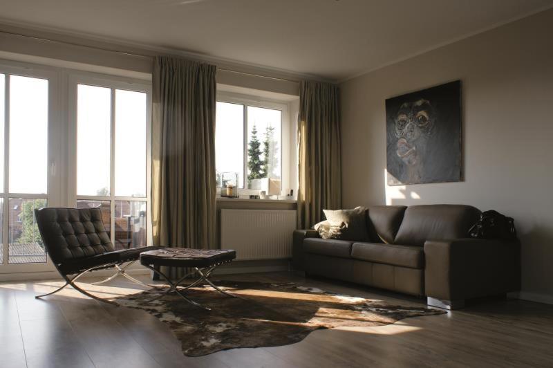 a living room with a leather couch and a table and window at Ferienwohnung Ariva in Timmendorfer Strand