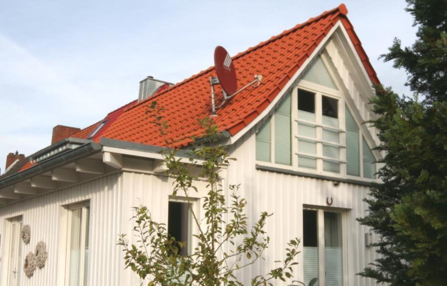 ティメンドルファー・シュトラントにあるFerienwohnung Glücksmomenteのオレンジ色の屋根の白い家