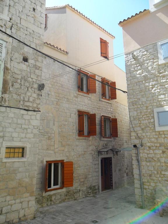 a stone building with wooden shutters on it at Villa Ruzica in Trogir