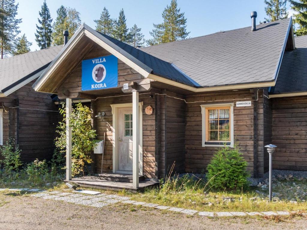 a small house with a blue sign on it at Holiday Home Villa koira nr2 by Interhome in Vuokatti