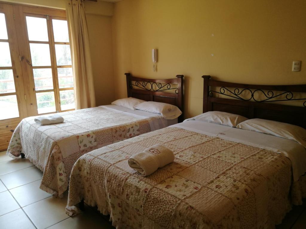 Postel nebo postele na pokoji v ubytování Las Cumbres INN