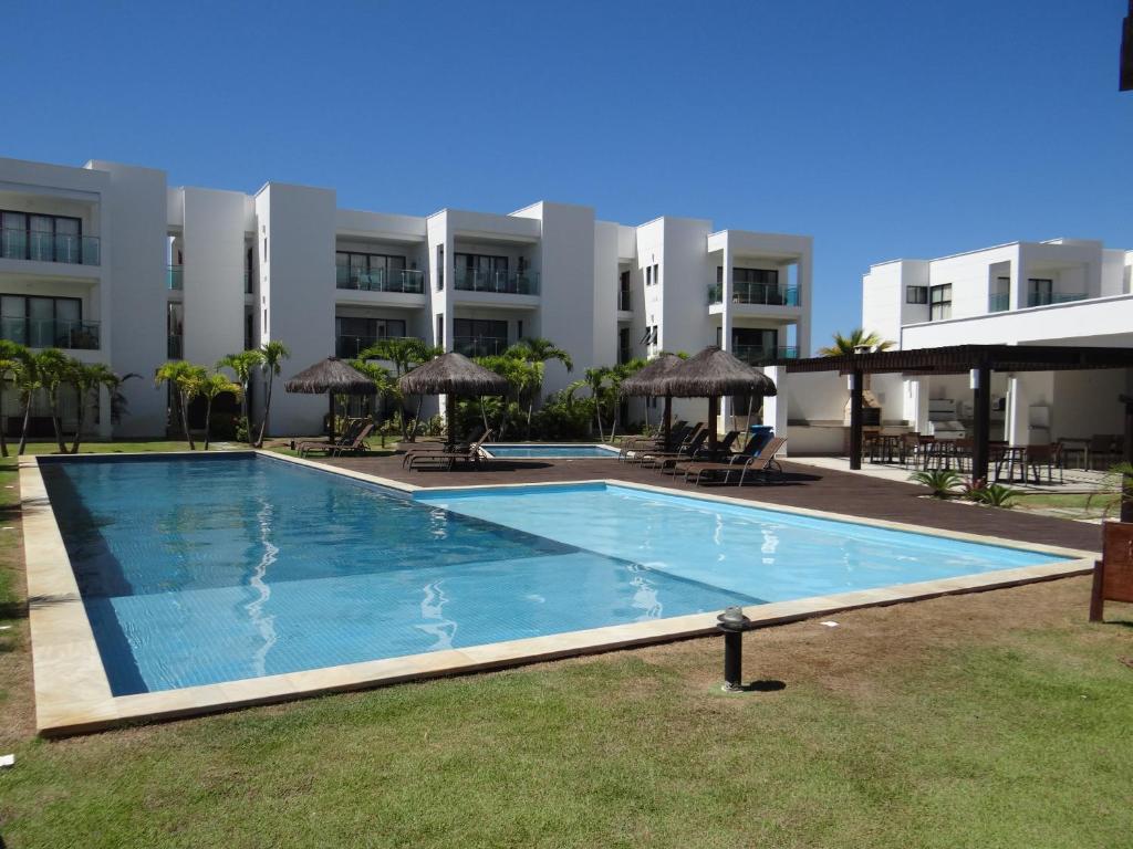a large swimming pool in front of a building at Apartamento no Complexo Iberostate in Acu da Torre