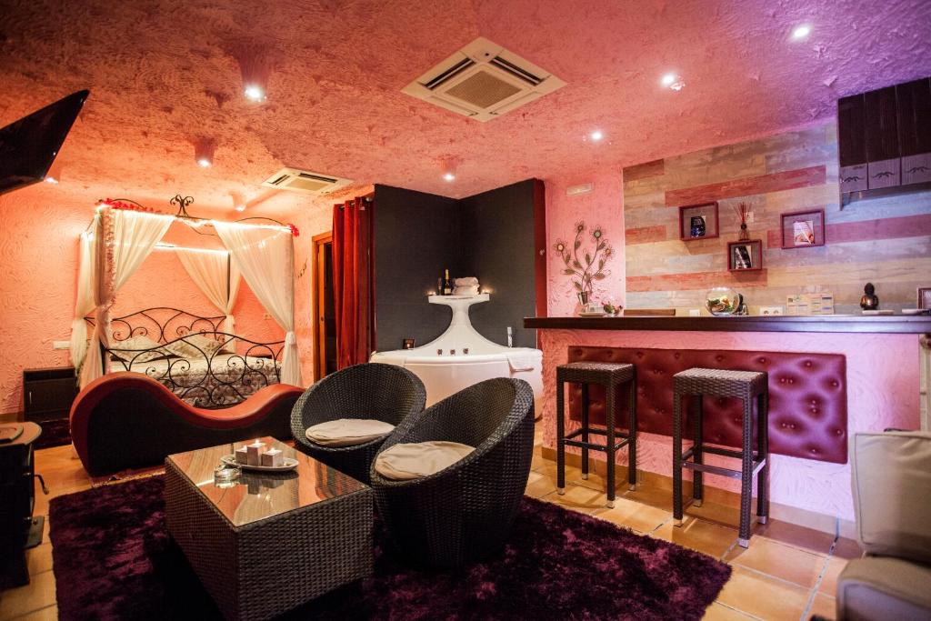 uma sala de estar com um bar com cadeiras e uma mesa em luxury suite em Ciempozuelos