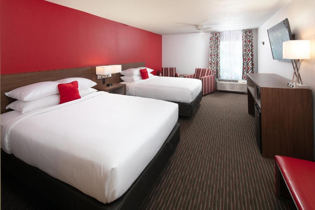 a hotel room with two beds and a red wall at Red Lion Hotel Orlando Lake Buena Vista South- Near Disney in Kissimmee
