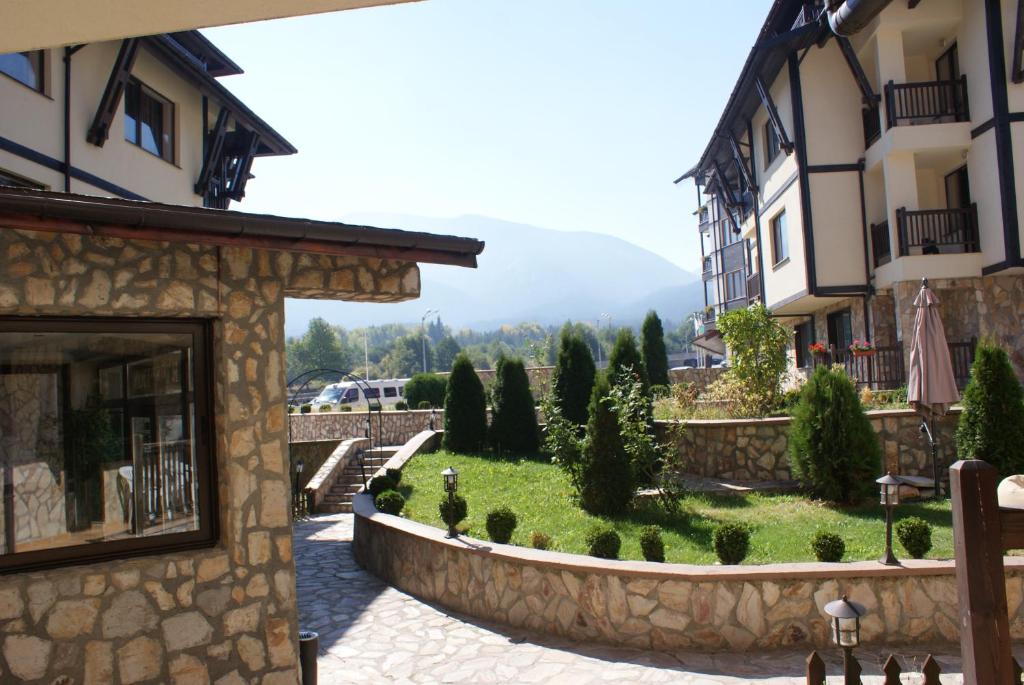 a view of a garden between two buildings at Mountain Top Mina in Bansko
