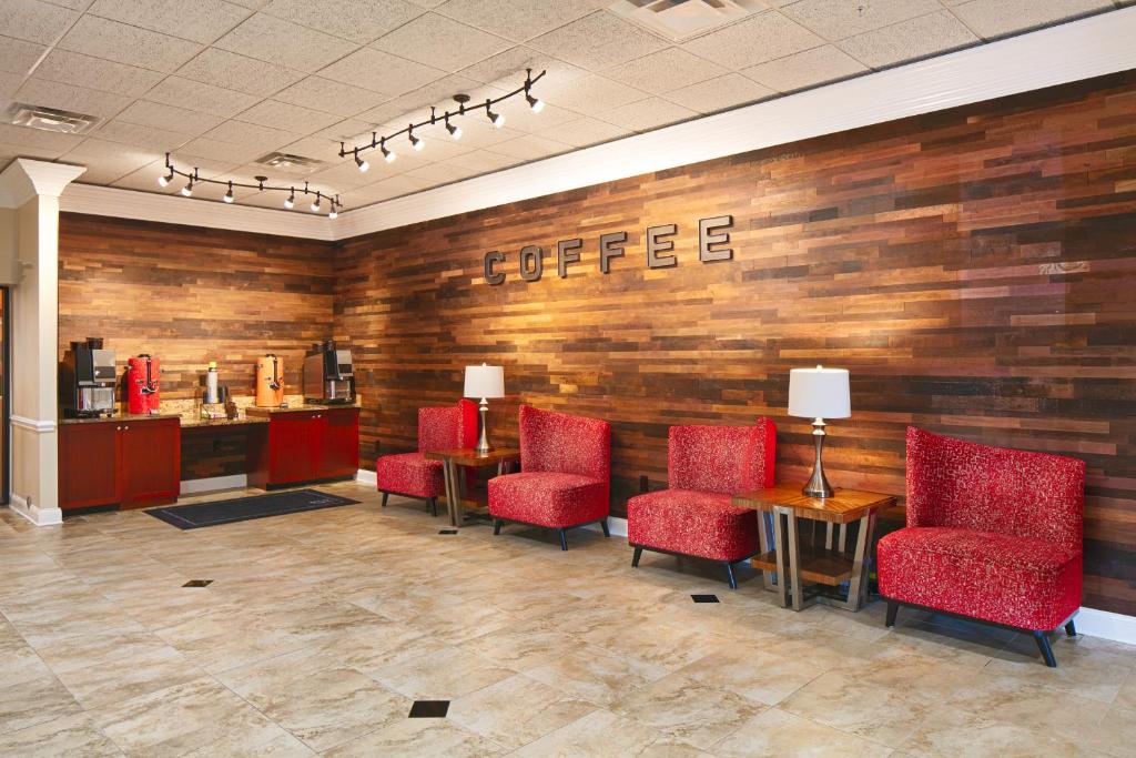 a waiting room with red chairs and a coffee bar at Red Lion Hotel Orlando Lake Buena Vista South- Near Disney in Kissimmee