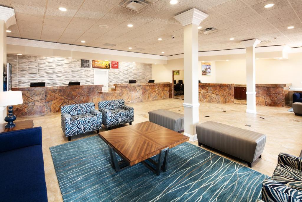 a lobby with a waiting room with couches and a table at Red Lion Hotel Orlando Lake Buena Vista South- Near Disney in Kissimmee