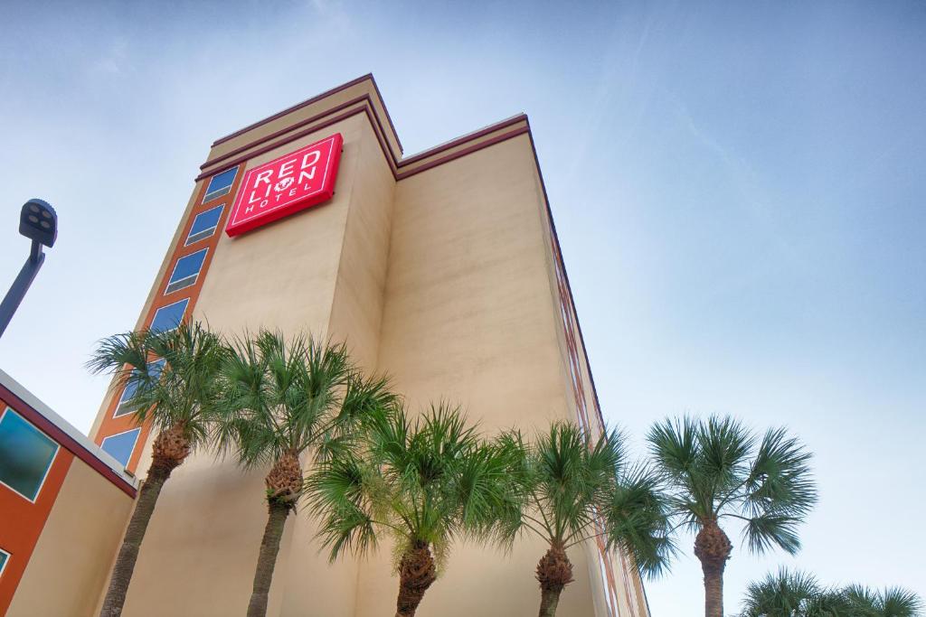 a building with palm trees in front of it at Red Lion Hotel Orlando Lake Buena Vista South- Near Disney in Kissimmee