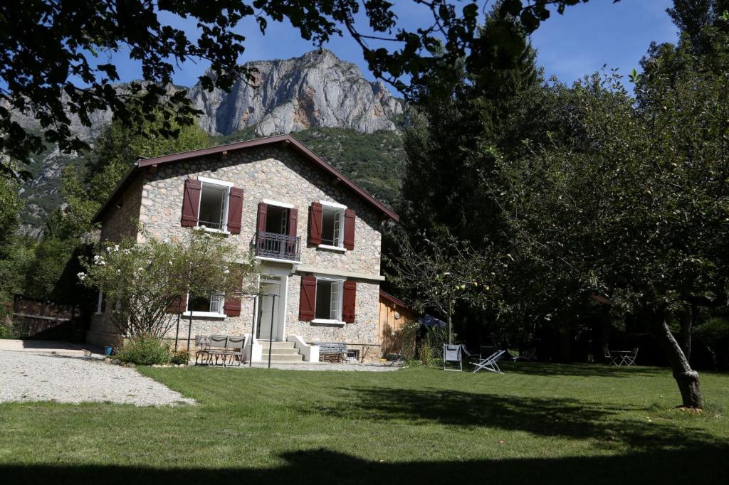 ein Steinhaus mit einem Berg im Hintergrund in der Unterkunft Villa Victoire in Aulos