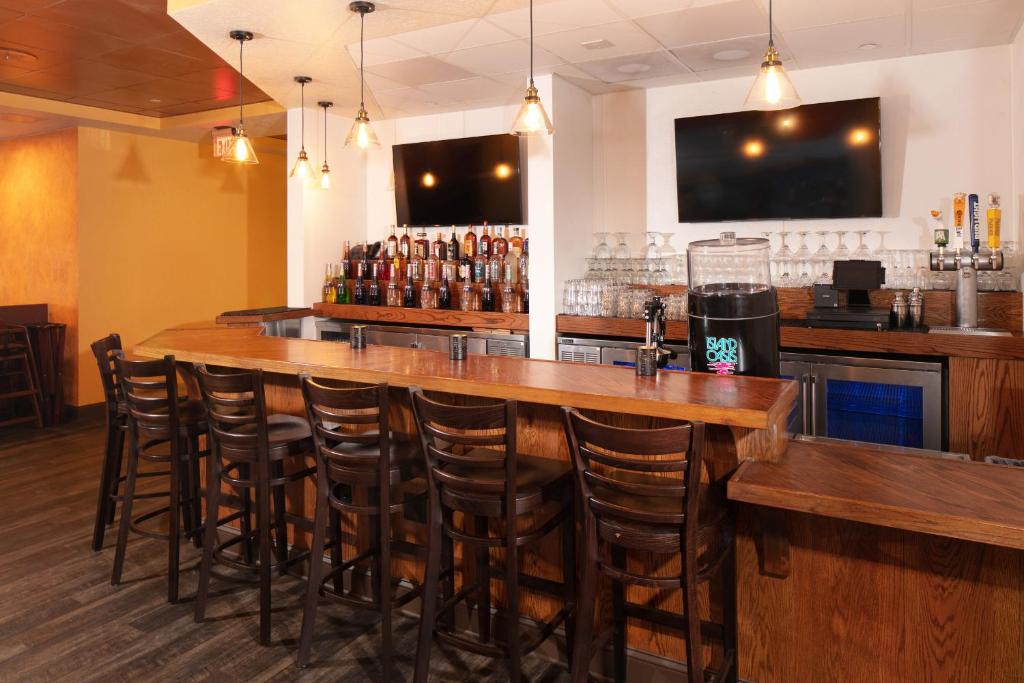 a bar with wooden bar stools in a restaurant at Red Lion Hotel Orlando Lake Buena Vista South- Near Disney in Kissimmee