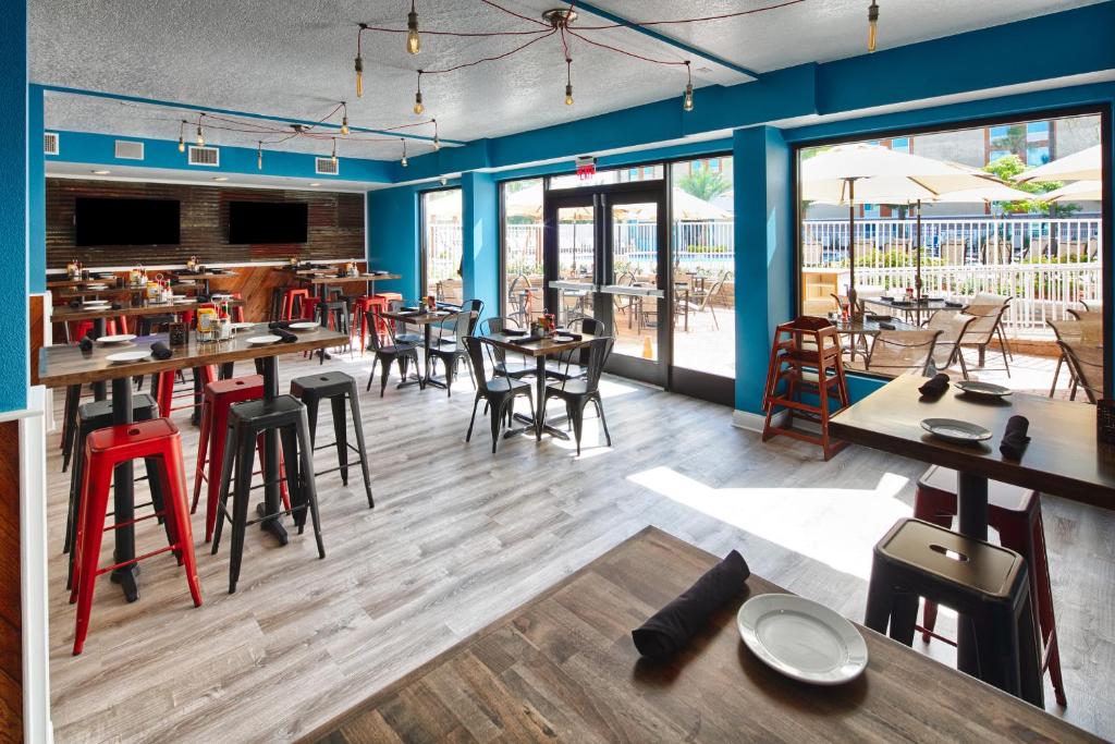 a restaurant with blue walls and tables and chairs at Red Lion Hotel Orlando Lake Buena Vista South- Near Disney in Kissimmee