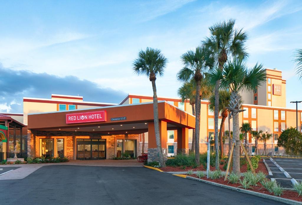 an empty parking lot in front of a building with palm trees at Red Lion Hotel Orlando Lake Buena Vista South- Near Disney in Kissimmee